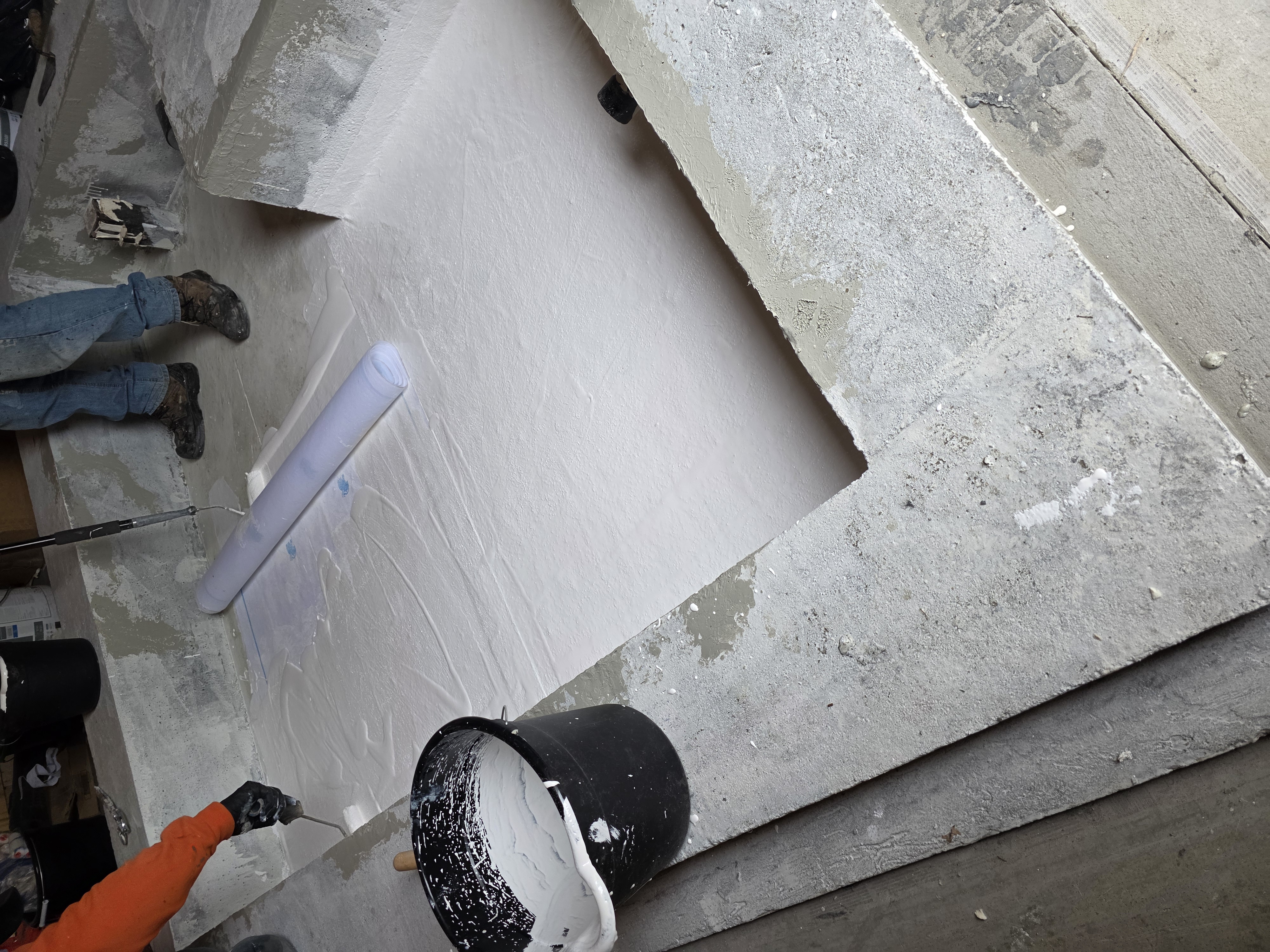 Exterior foundation wall coated with black waterproofing membrane during excavation