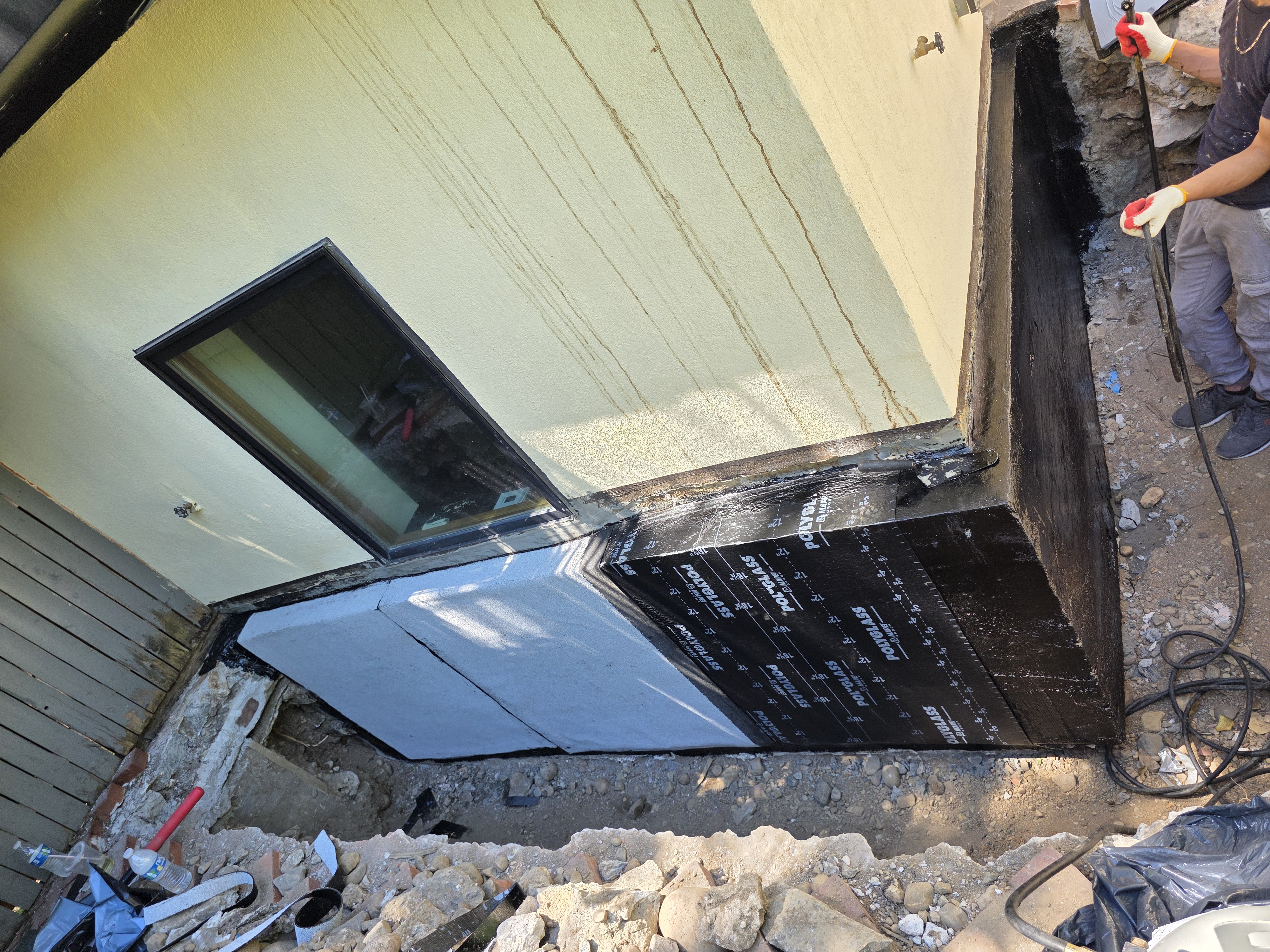 Waterproofing membrane applied to an exterior foundation window well