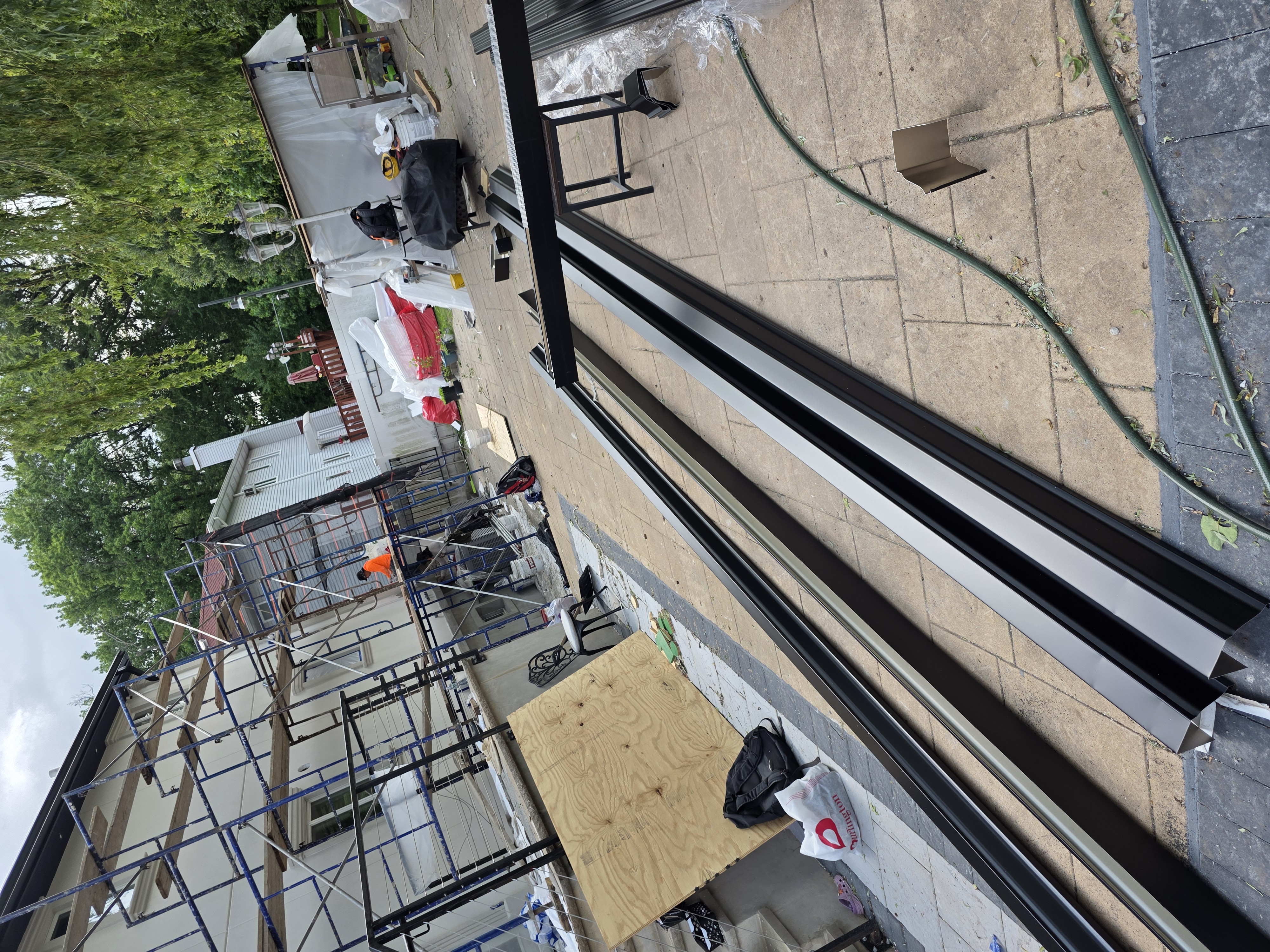 New gutter and downspout metal components staged for installation