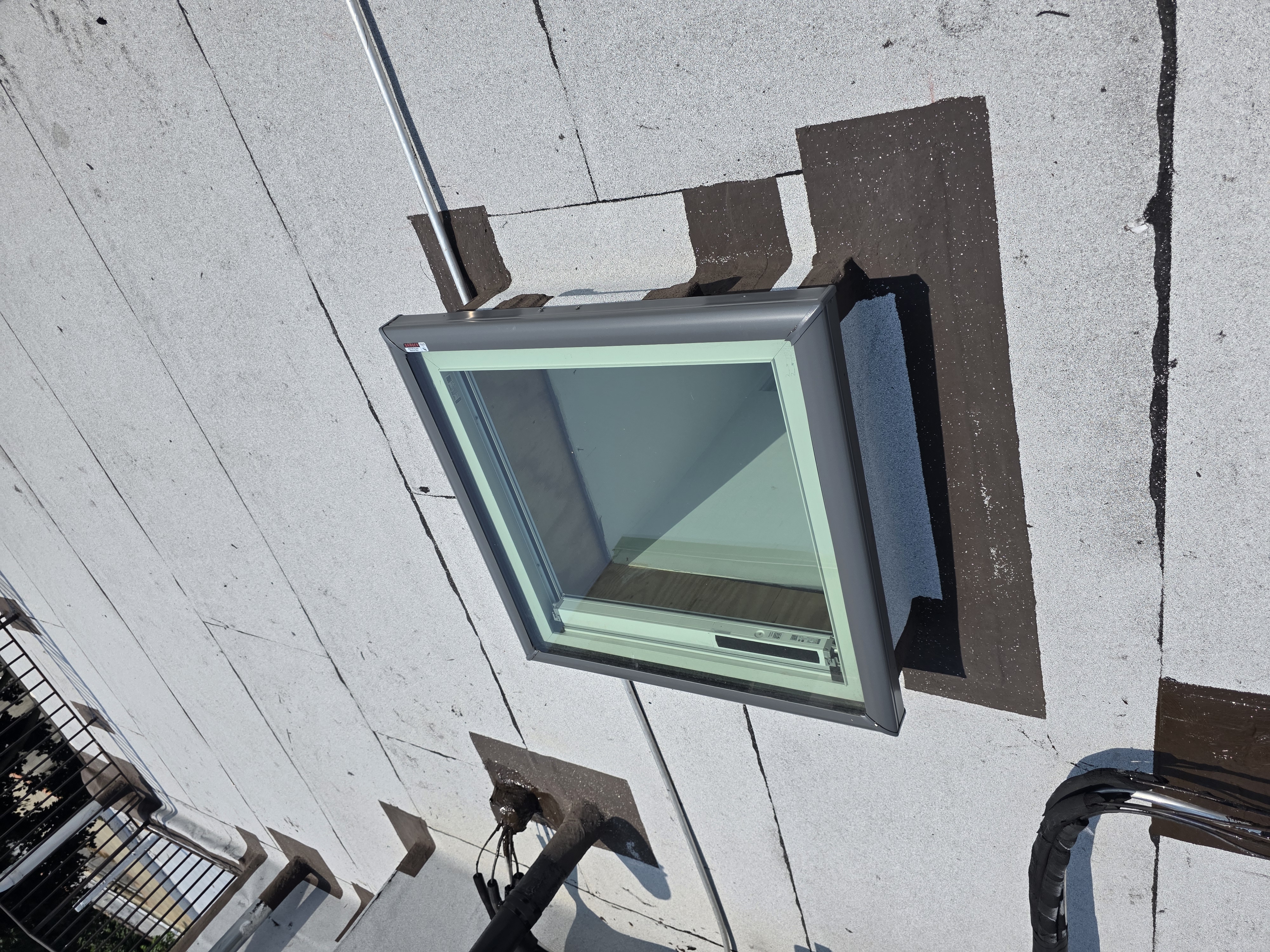 New skylight window installed in a flat roof with waterproof flashing