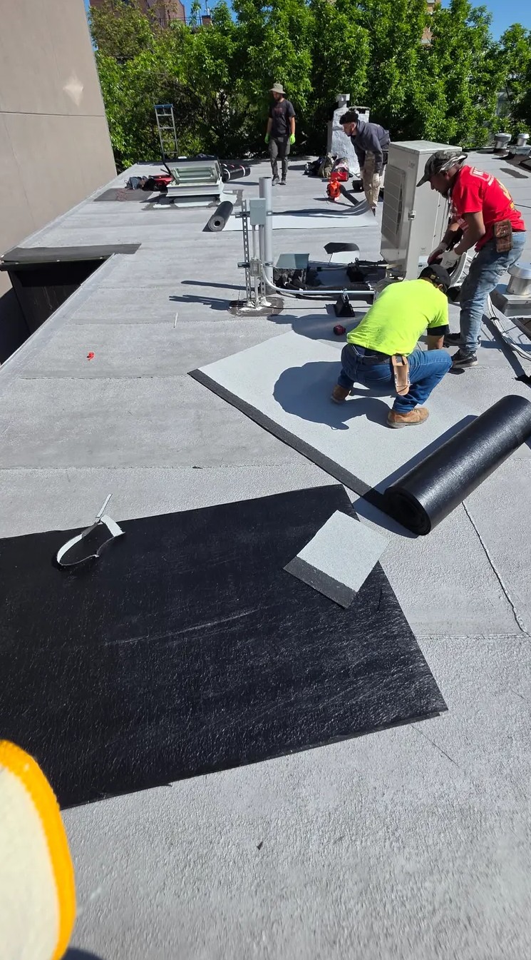 Roof On crew installing a flat roof on a Brooklyn building