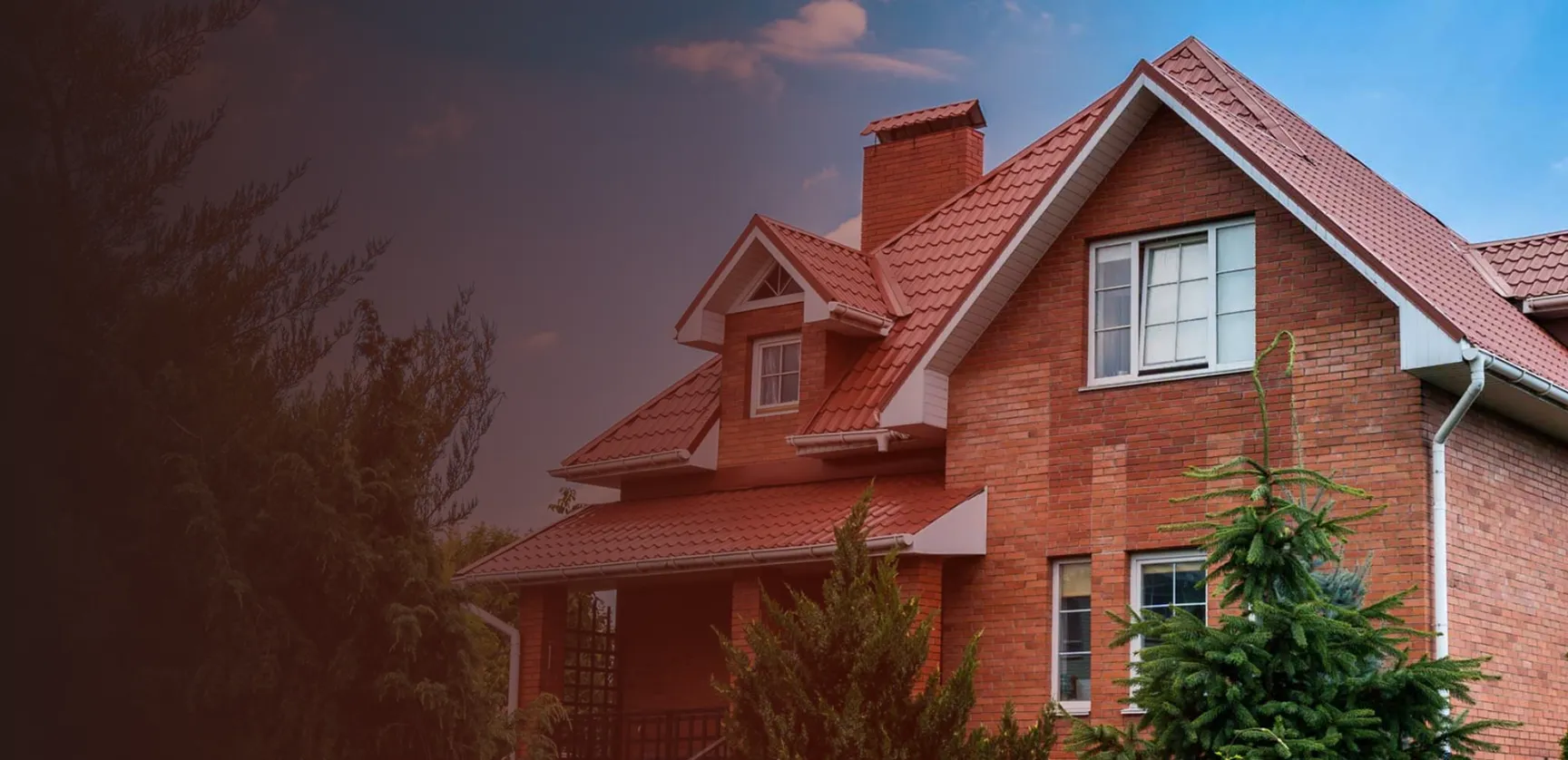 Red tile roof on a two-story brick home with dormer windows